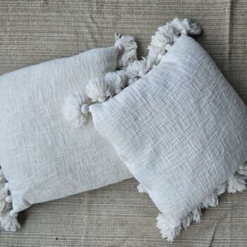 Coussin blanc à pompons